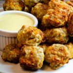 air fryer sausage balls on a white plate with honey mustard dipping sauce