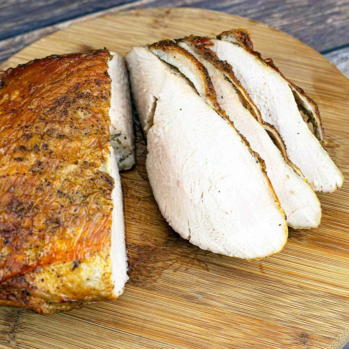 Sous Vide Turkey Breast with crispy skin on cutting board with 4 slices
