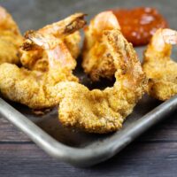 air fryer fried shrimp on a platter with cocktail sauce