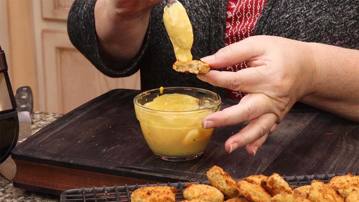 eating air fryer fried pickles with mustard sauce