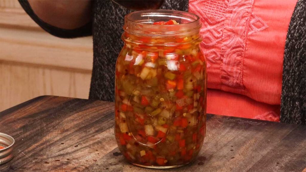 pint jar of pepper and onion relish on cutting board