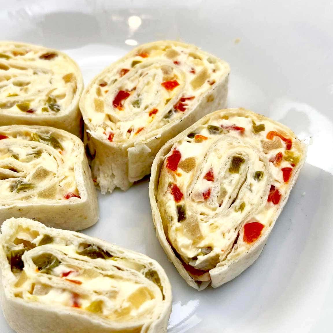 plate of party pinwheels with onion and pepper relish and cream cheese