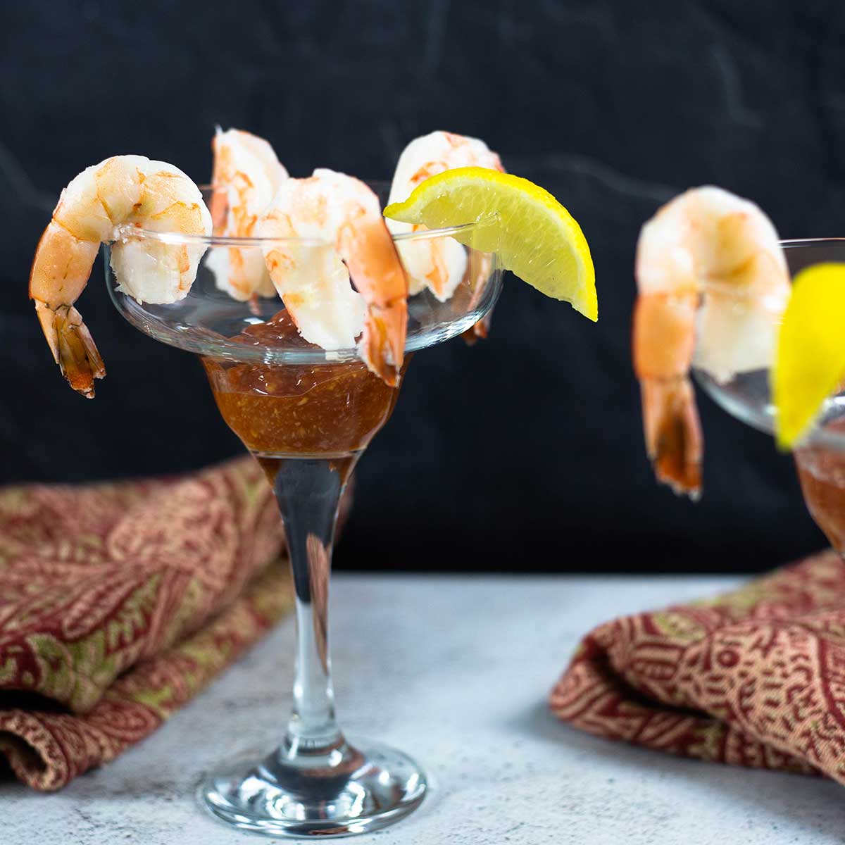 Shrimp cocktail in a margarita glass with a 4 shrimp and a lemon wedge