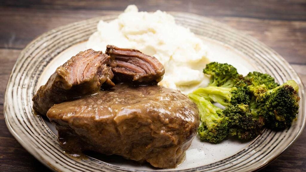 country style beef ribs on a plate with mashed potatoes and broccoli