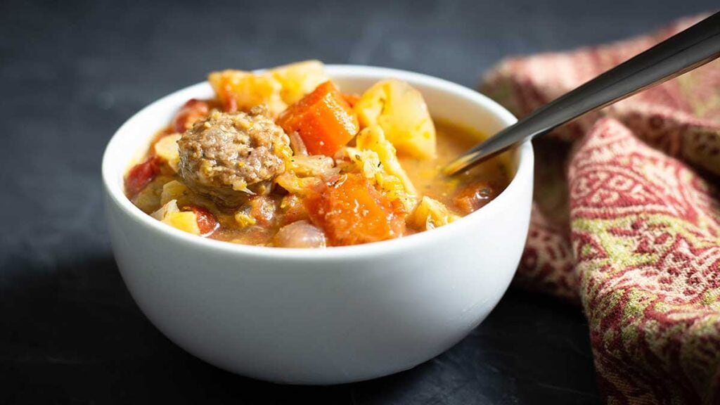 white bowl of cabbage and sausage soup