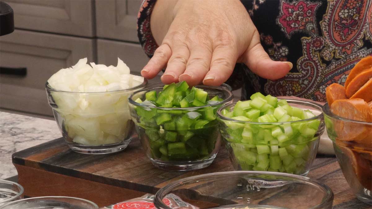 holy trinity of onions, green peppers, and celery diced in small 1 cup glass bowls.