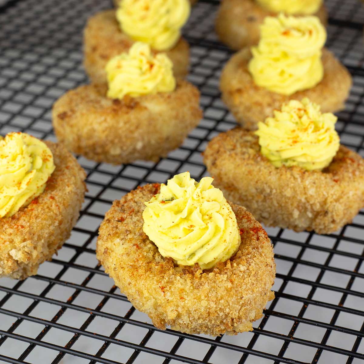 fried deviled eggs on a cooling rack.