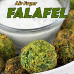 air fryer falafel in white bowl with a glass bowl of sauce in the center.