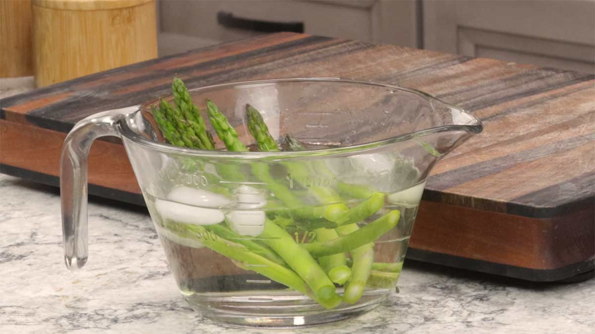 steamed asparagus stalks in an ice bath.