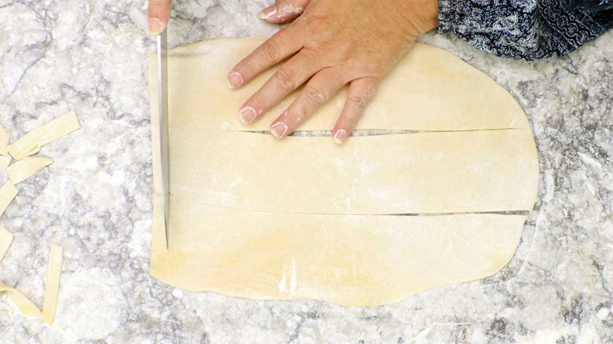 cutting egg noodles with the flat sheet of dough.