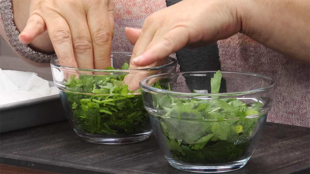 pressing down the herbs in the measuring cups to get one cup packed