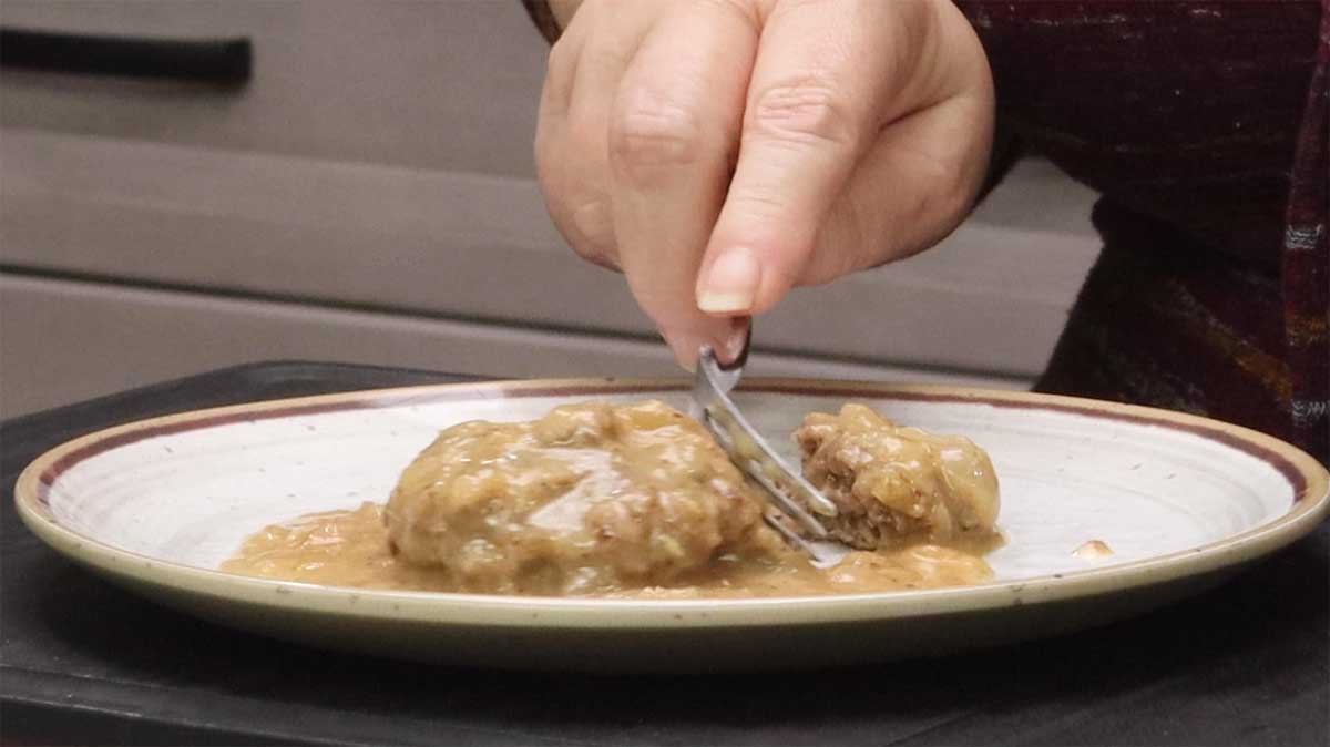 cutting into the salisbury steak with a fork.
