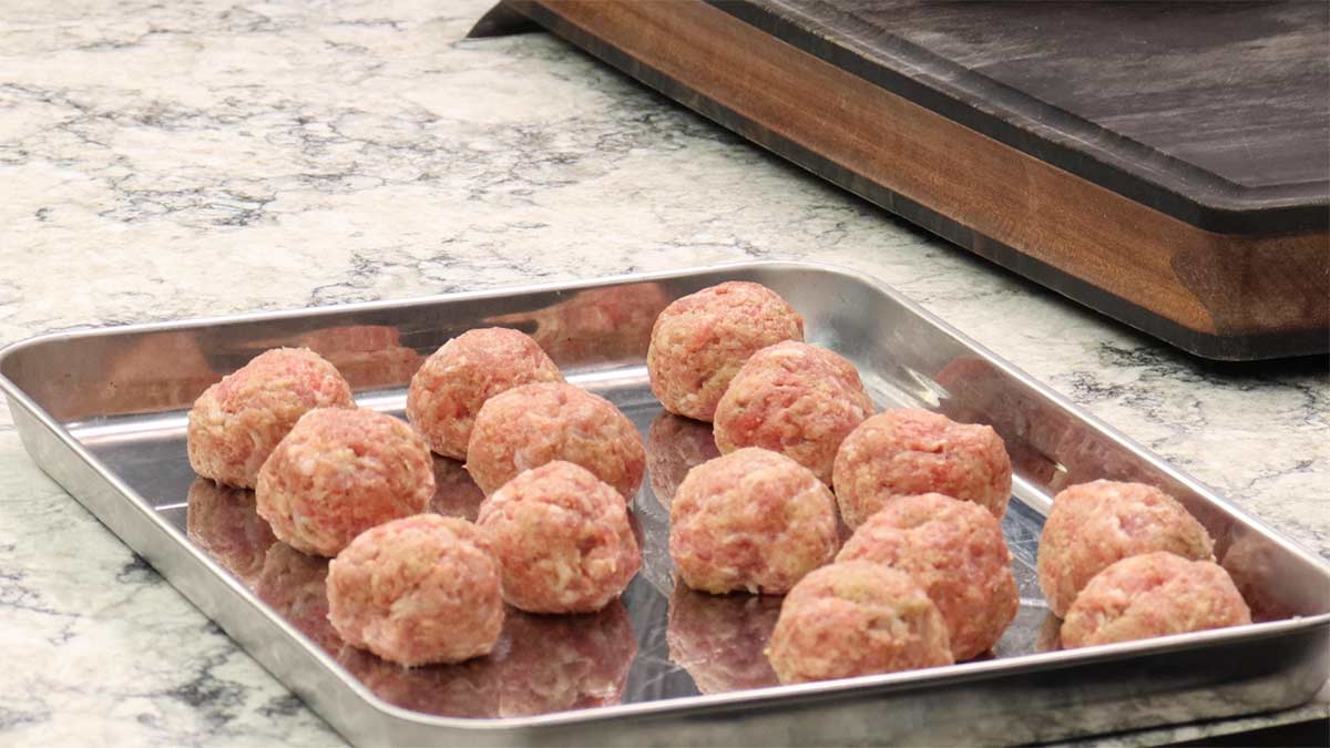 Homemade meatballs on tray before browning.