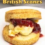 Air fryer scone on a white plate with clotted cream and strawberry jam.