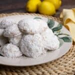 Lemon Cooler Cookies on a plate with Lemons in the background.