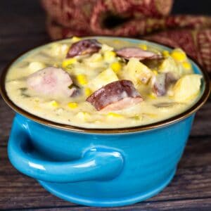 Sausage and corn chowder in a blue bowl.
