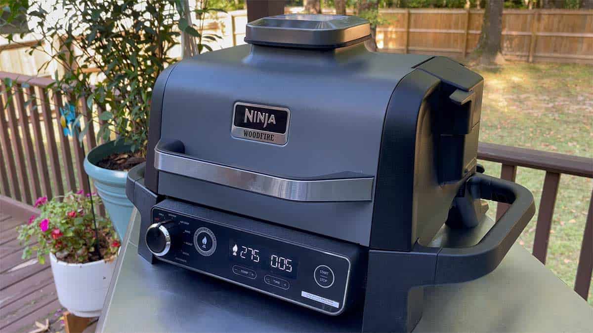 Ninja Woodfire Grill and Smoker on table outside.