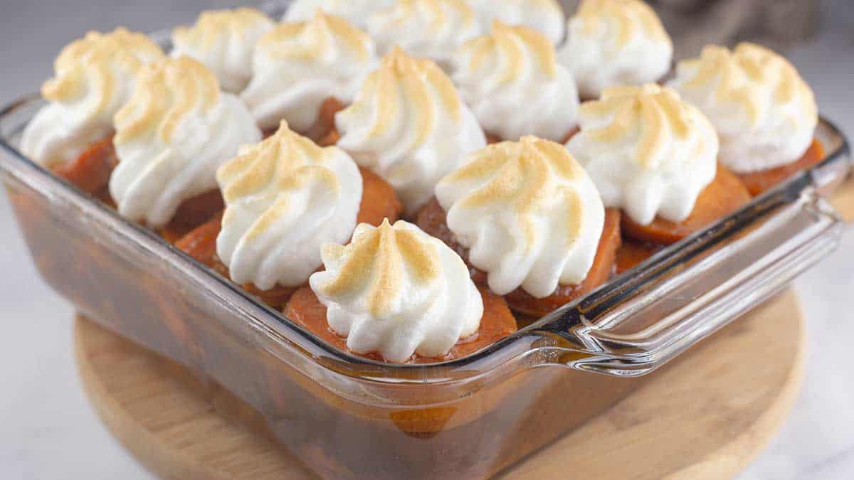Slow Cooker Candied Sweet Potatoes in a glass dish with golden meringue on top. 