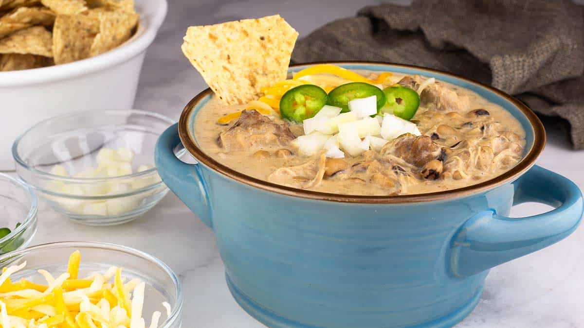 black eyed pea white chicken chili in a bowl with garnishes on top. 