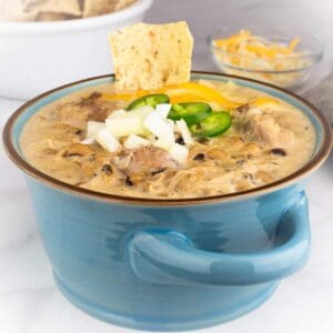 black eyed pea white chicken chili in a bowl with garnishes on top.