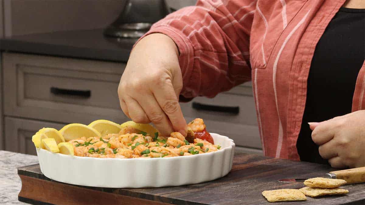 scooping cold shrimp dip onto a cracker. 