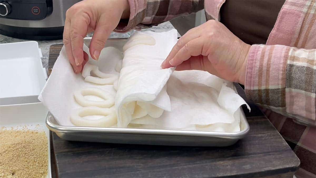air fryer calamari on a tray with paper towels.