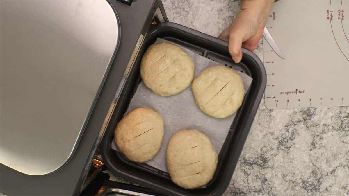 Putting the tray of pretzel rolls into the combi.