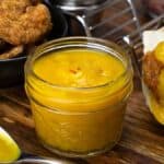 jar of mango sauce next to shrimp tacos.
