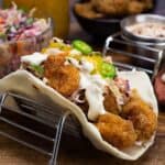 air fryer shrimp taco topped with slaw, mango sauce, sliced jalapeno peppers.