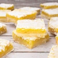 Lemon Bars Cut on white plank boards.