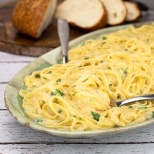one-pot fettuccine alfredo on platter garnished with parsley.