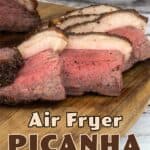 Sliced Rare Picanha roast on a wood cutting board with a salad behind it.
