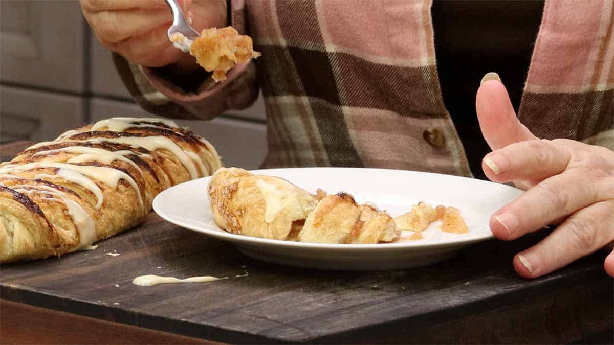 apple puff pastry on a plate and a piece on a fork.