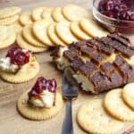 Smoked Cream Cheese on a wood board with crackers and cranberry jelly.