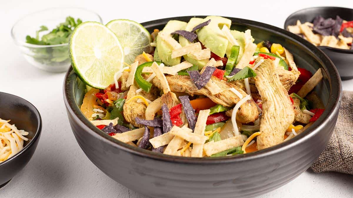 Chicken fajita salad in a bowl with toppings. 