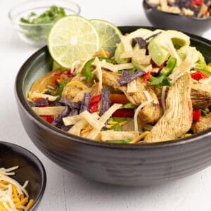 Chicken fajita salad in a bowl with toppings.