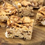 Cinnamon Toast Crunch bars cut into squares and arranged on parchment paper, showing their golden cereal texture and chewy marshmallow layers