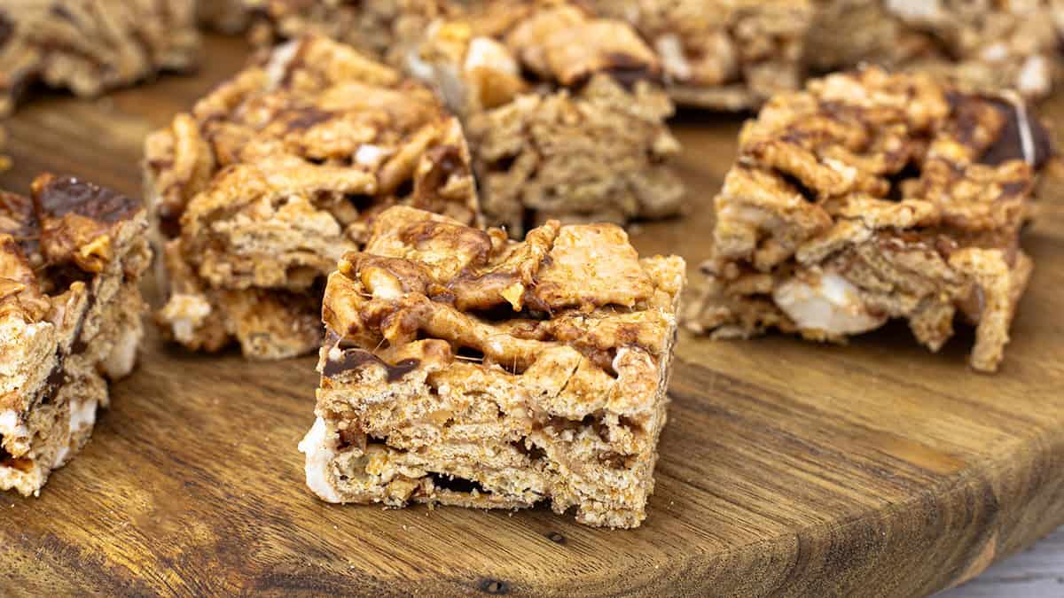 Cinnamon Toast Crunch bars cut into squares and arranged on parchment paper, showing their golden cereal texture and chewy marshmallow layers