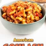Pinterest pin image showing a teal bowl filled with American goulash made with elbow macaroni, ground beef, and tomatoes, with text overlay reading American Goulash Pressure Cooker Recipe by The Salted Pepper.
