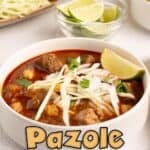 Pinterest pin of Pork Pozole Rojo in a white bowl topped with shredded cabbage, onion, radishes, cilantro, and a lime wedge, with crispy tortillas and lime wedges in the background.