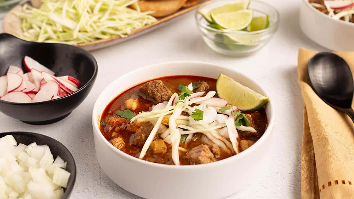 A pot of pork pozole rojo with the rich red chile broth, tender pork, and white hominy