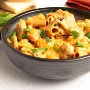 A close-up square shot of One-Pot Marry Me Chicken (Pressure Cooker), showing creamy sauce coating rigatoni pasta and chicken with a basil garnish.